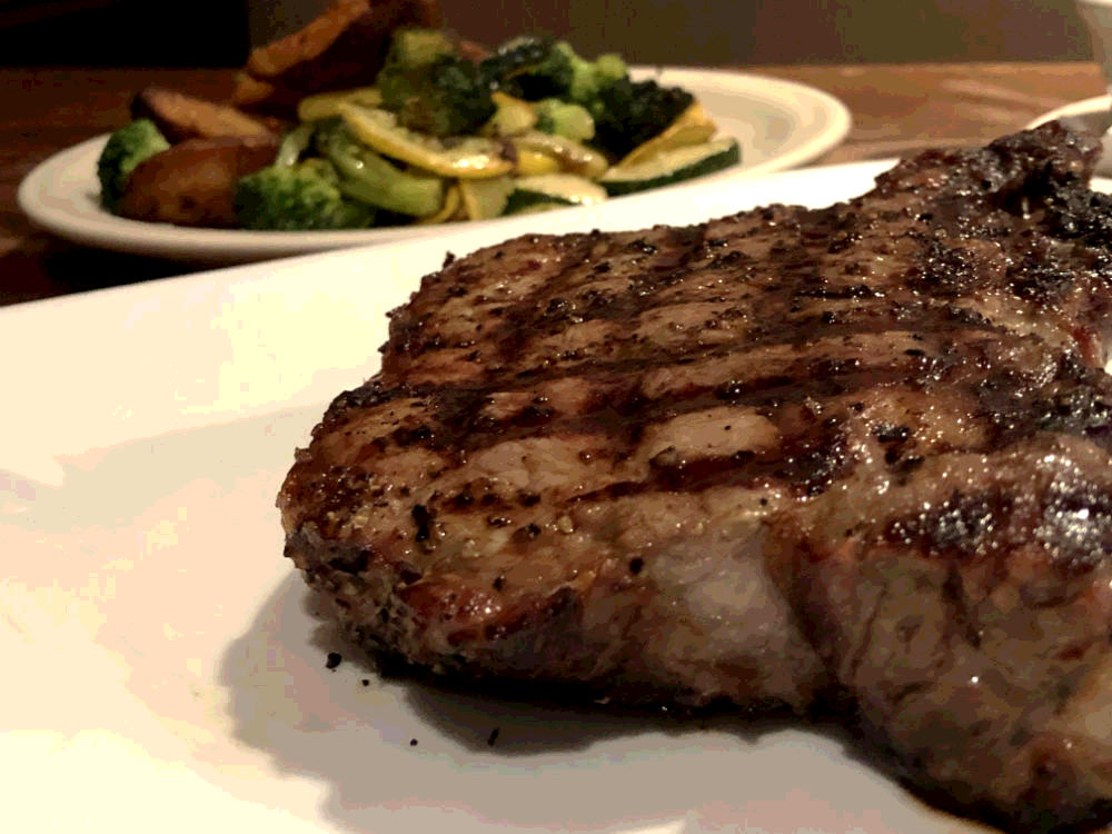 new york strip steak with potato wedges and veggies dinner